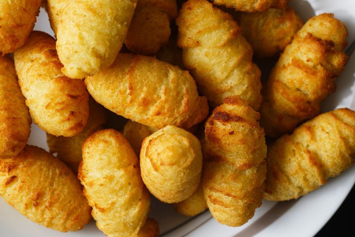 Bolinhos dourados e crocantes servidos em prato branco