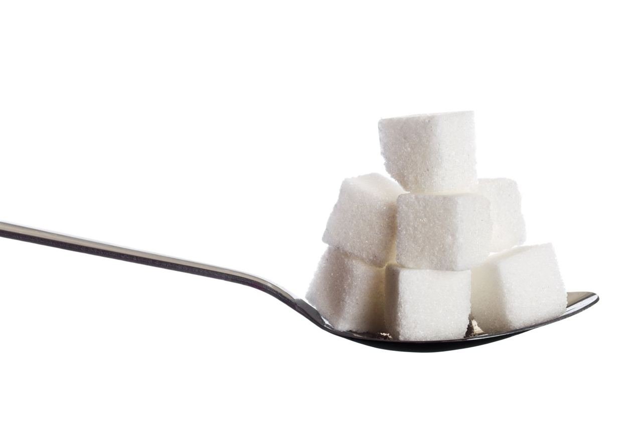 Colheres com açúcar mostrando a quantidade escondida em alimentos