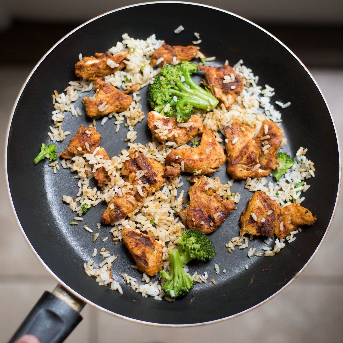 Frango, arroz e brócolis refogados juntos em frigideira