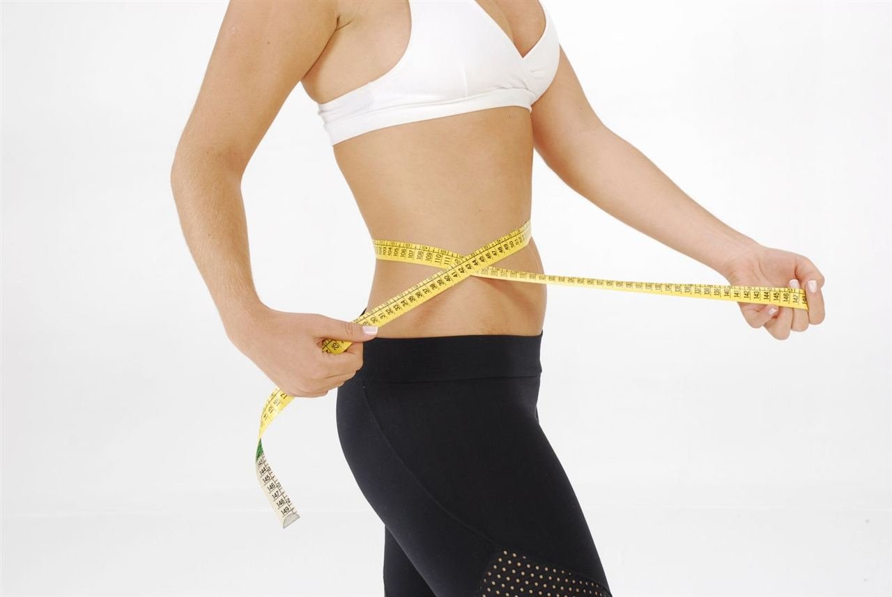 Pessoa medindo a circunferência abdominal com fita métrica