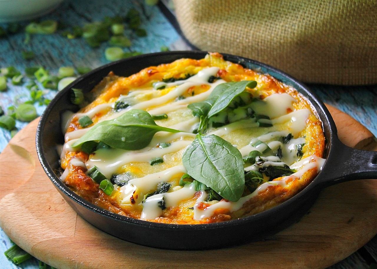 Omelete de claras dobrada com espinafre e queijo cottage no prato