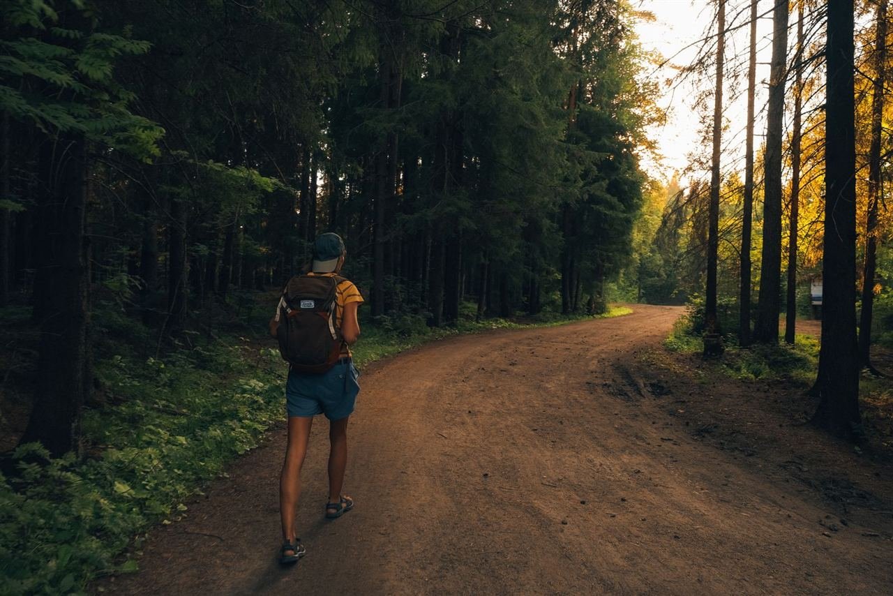 Pessoa caminhando ao ar livre com mochila carregada nas costas