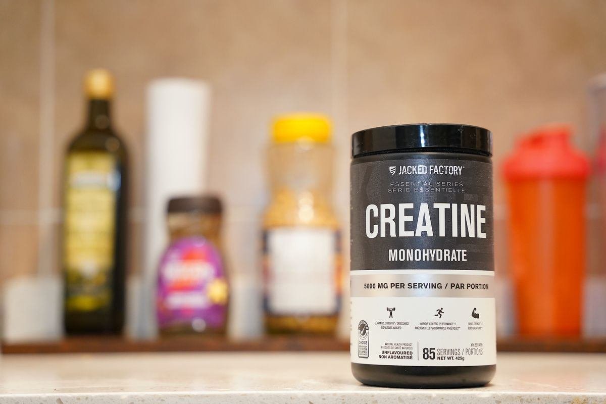 Pote de creatina monoidratada sobre bancada de cozinha
