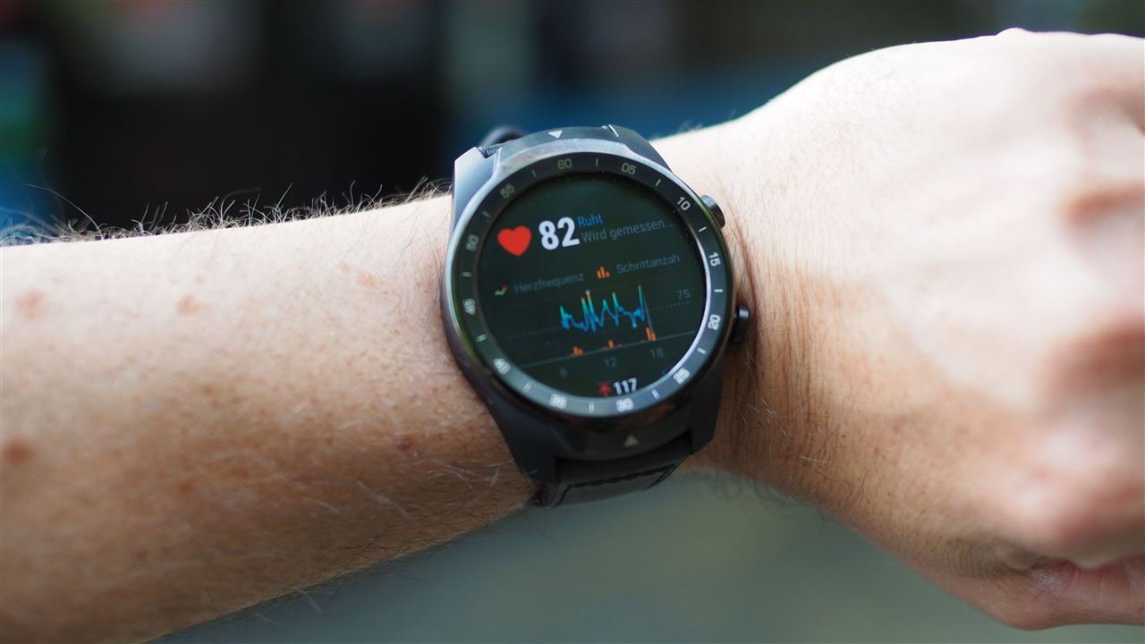 Smartwatch no pulso exibindo dado de frequência cardíaca em close