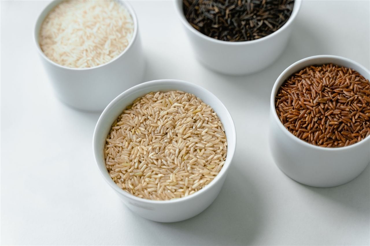 Quatro tigelas com diferentes tipos de arroz e grãos, representando alimentos de índice glicêmico variado