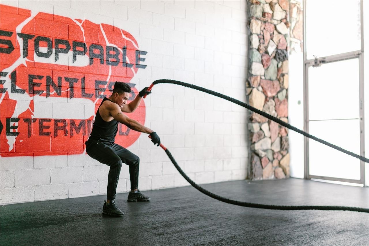 Mulher realizando exercício de battle rope em treino HIIT de alta intensidade