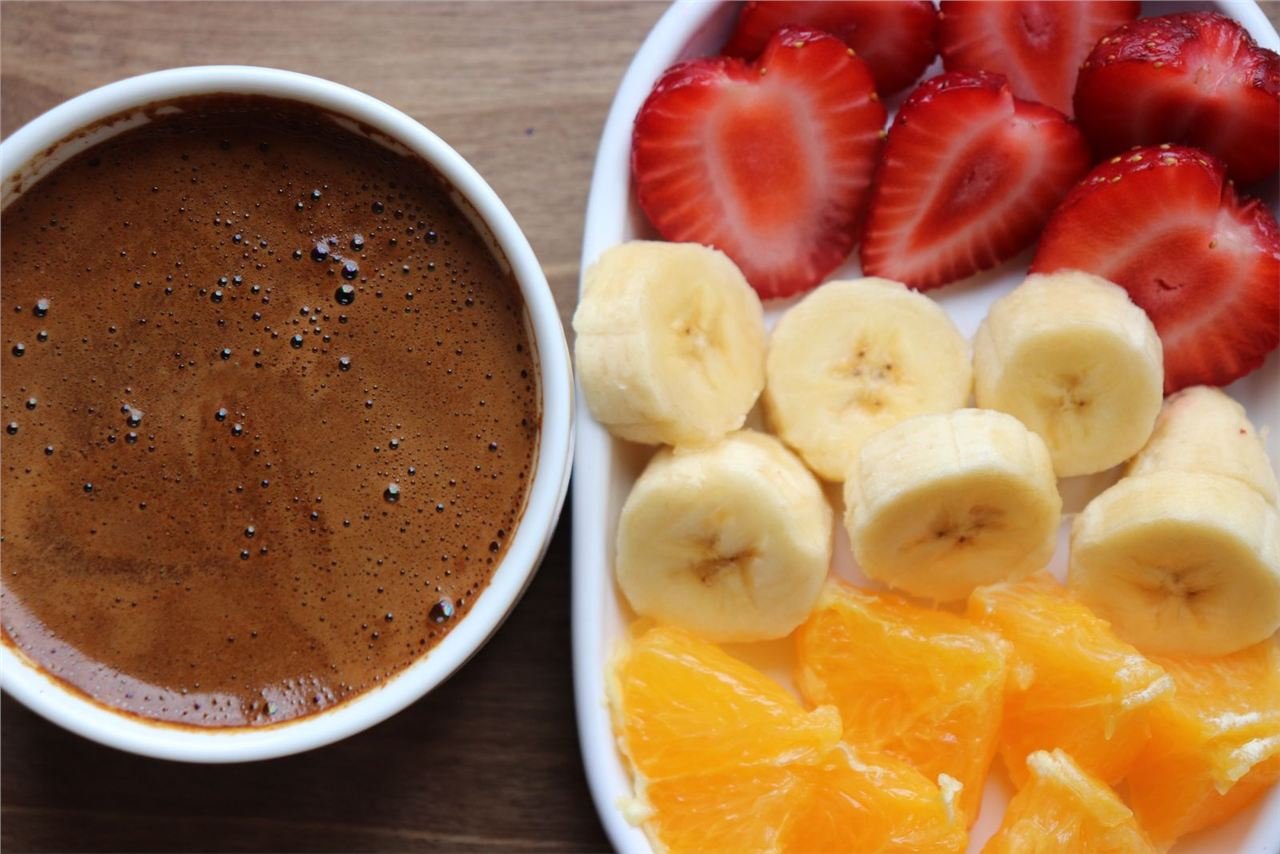 Bowl com banana fatiada ao lado de café gelado, ingredientes da vitamina energética