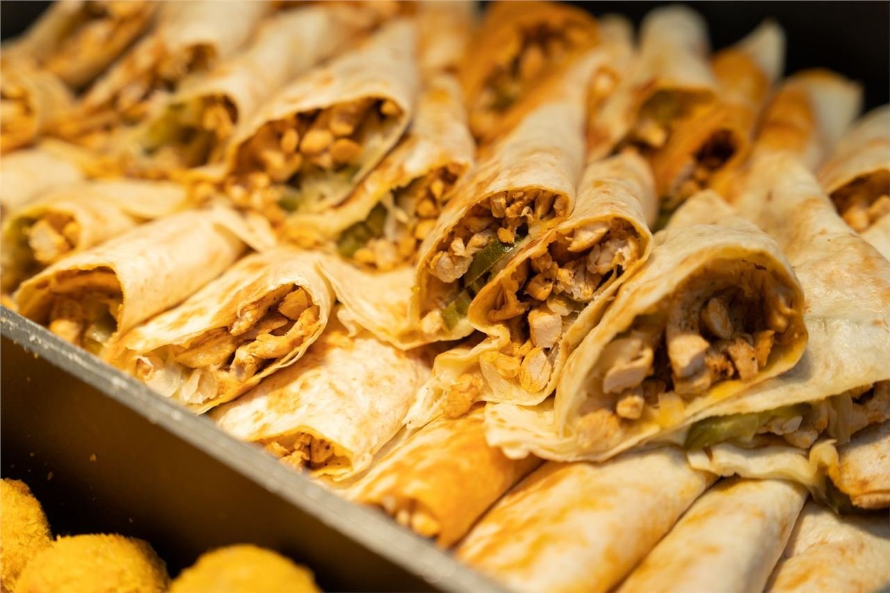 Wraps enrolados recheados com frango grelhado, vistos em corte